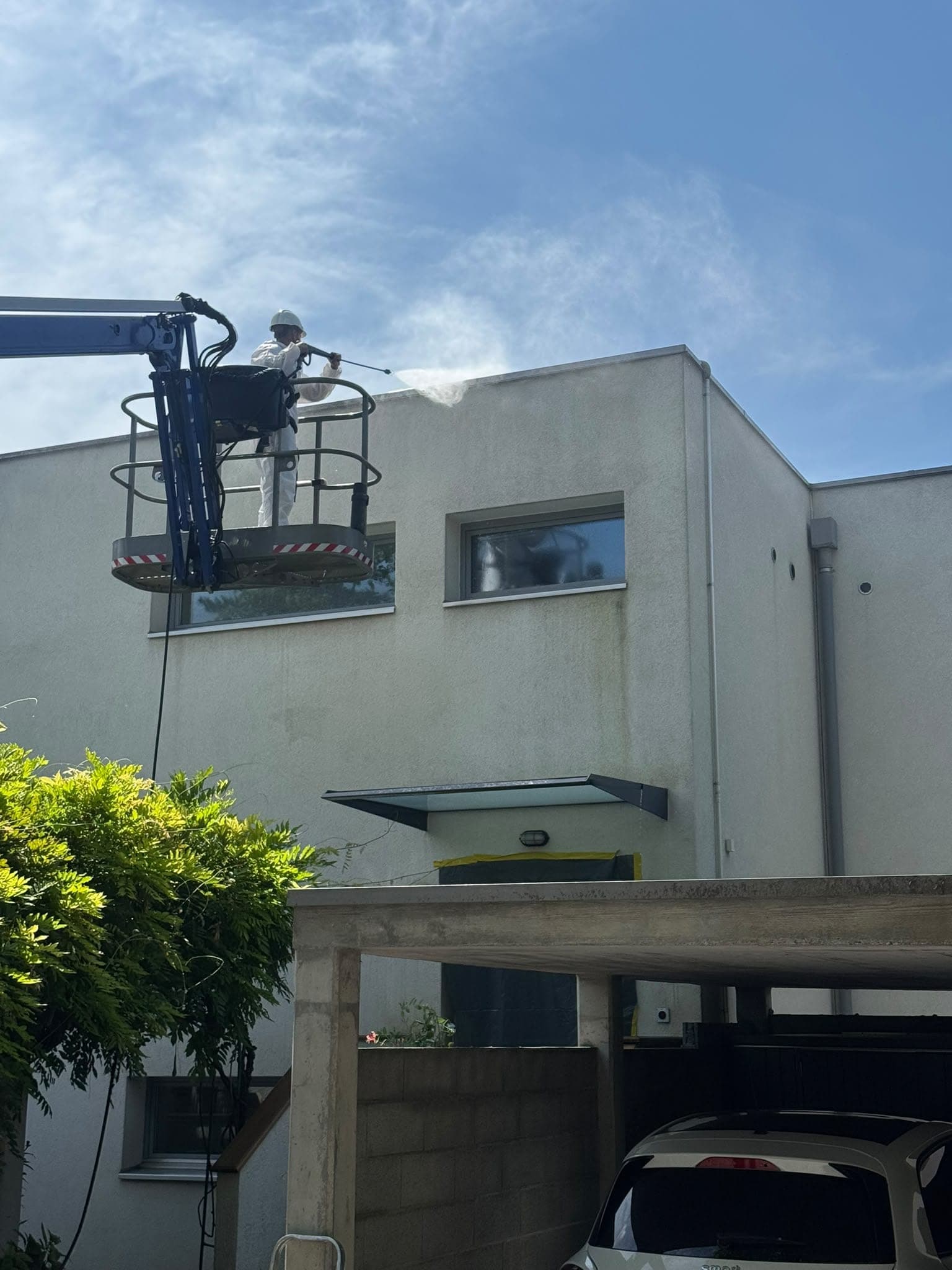 Nacelle bleue déployée le long d'une villa en cours de traitement de façade