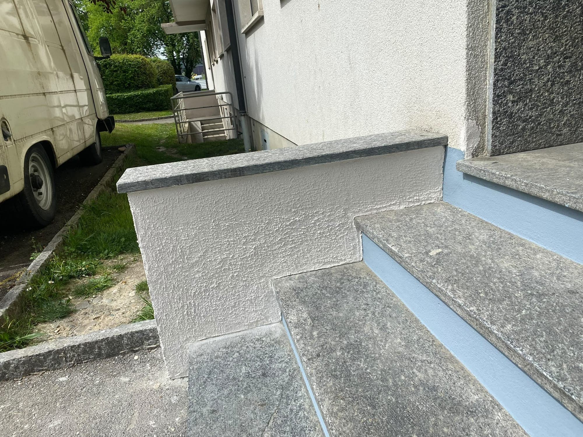 Muret d'escalier remis à neuf, crépi blanc net sous la couvertine en granit