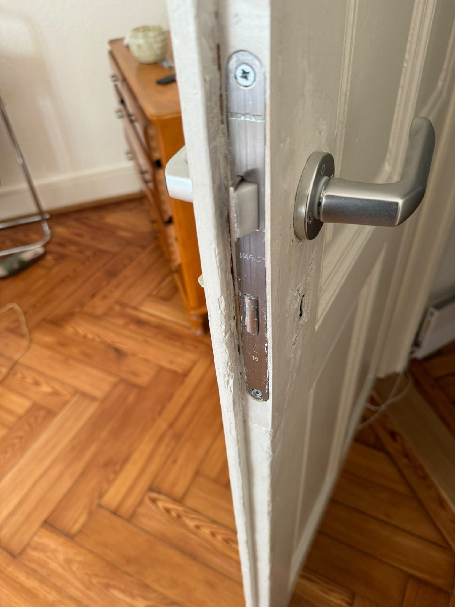Serrure neuve et poignée en aluminium posées sur une porte intérieure